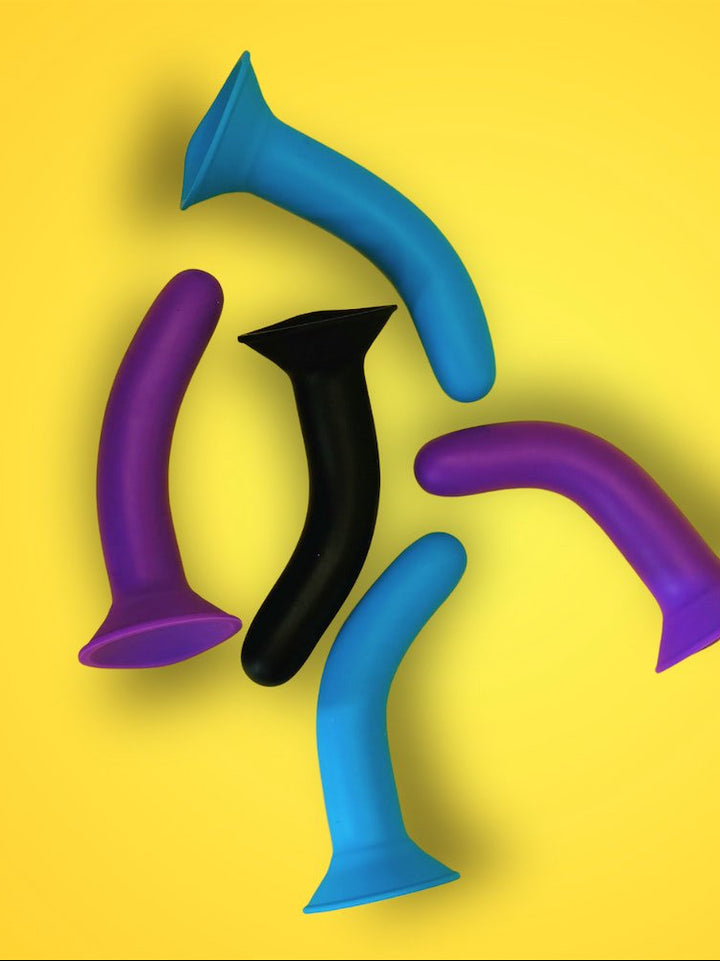 Four colorful plastic toys on a yellow background